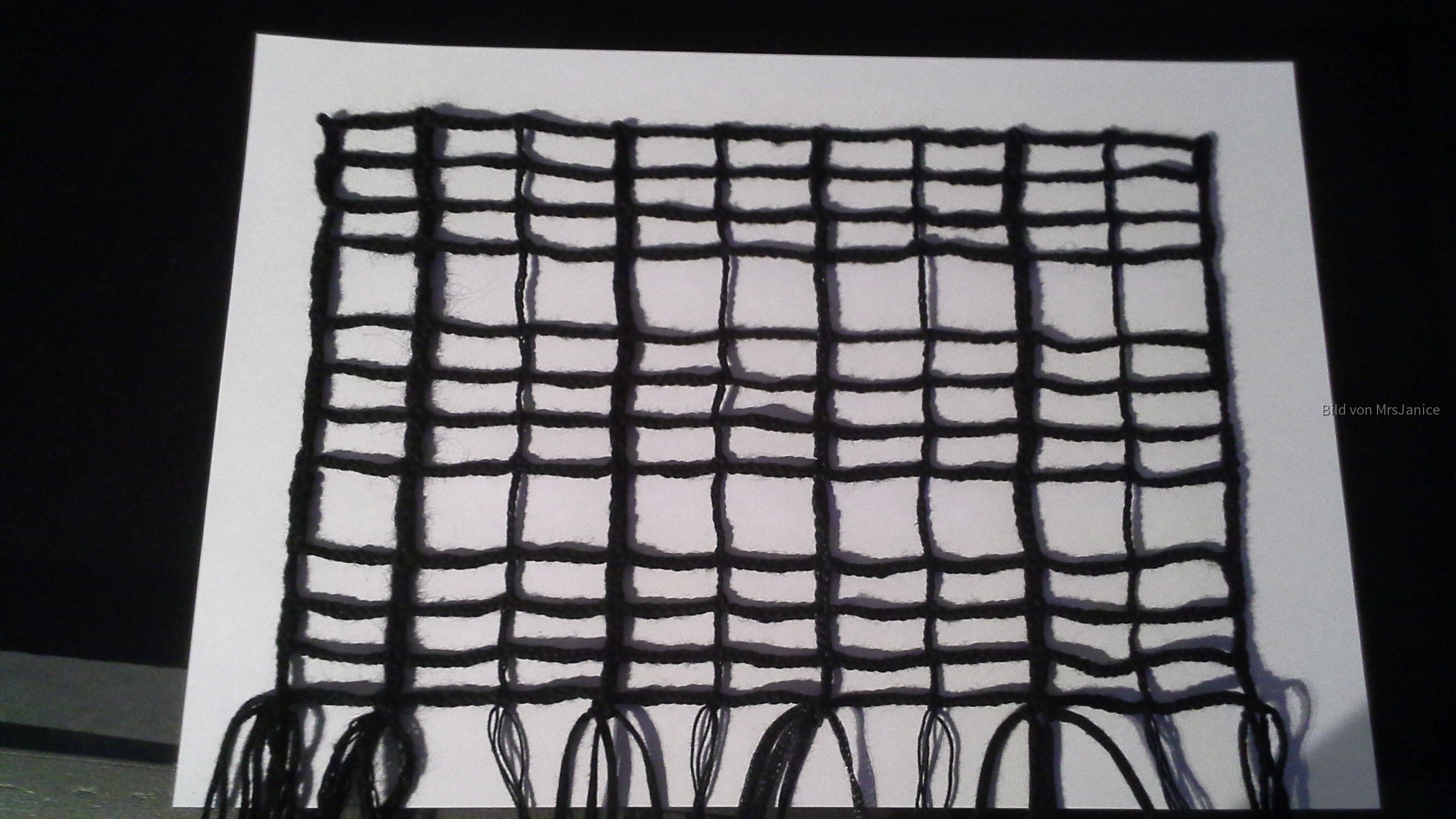 Schwarzes Netz aus normalen, verschiedenen Garnen geklöppelt